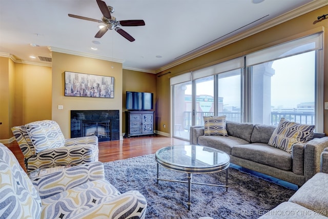 living room featuring ceiling fan, hardwood / wood-style flooring, and crown molding