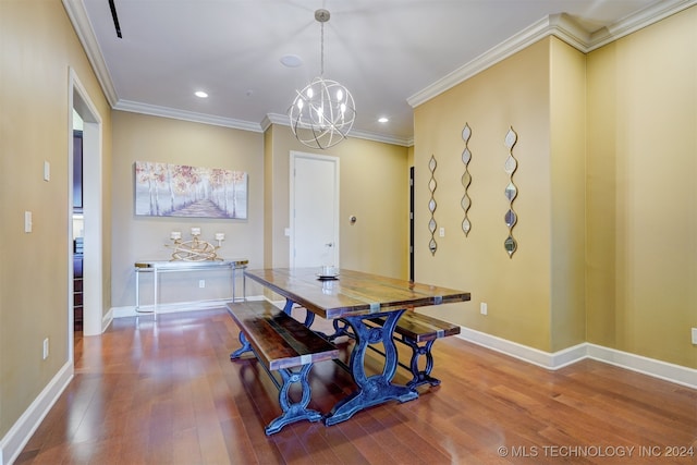 dining space with hardwood / wood-style flooring, crown molding, and a chandelier