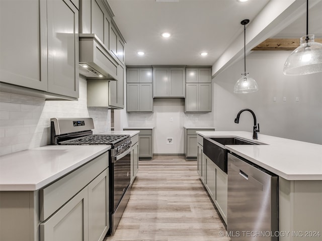 kitchen featuring pendant lighting, gray cabinets, stainless steel appliances, and custom exhaust hood