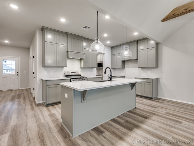 kitchen with gray cabinetry, sink, stainless steel gas range oven, and light hardwood / wood-style floors