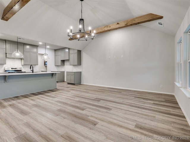 kitchen with gray cabinets, light hardwood / wood-style floors, hanging light fixtures, and beam ceiling