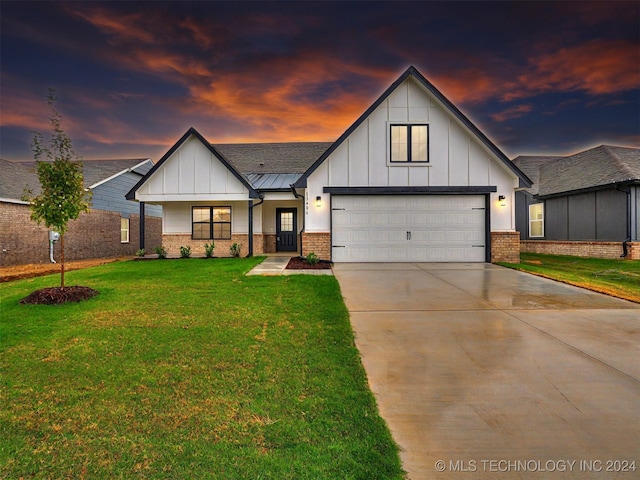 modern farmhouse style home with a lawn and a garage