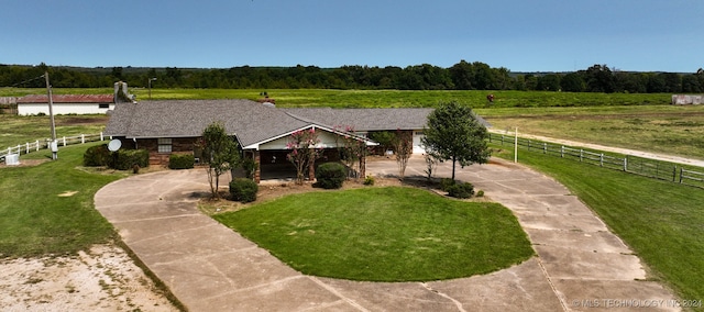 view of front of house with a front lawn and a rural view