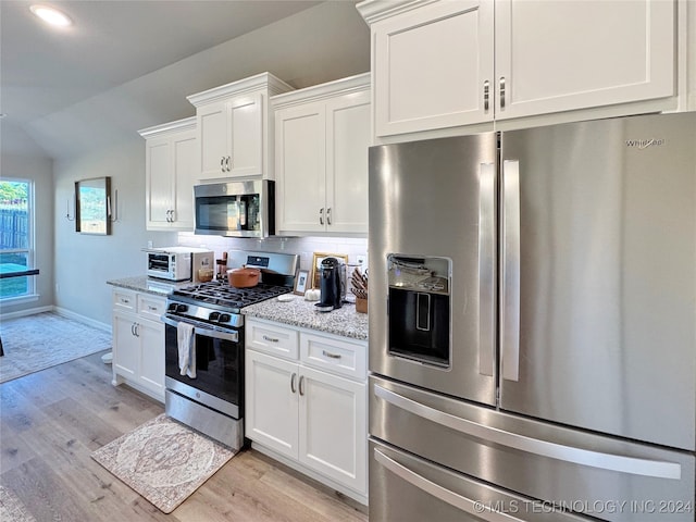 kitchen featuring light stone countertops, light hardwood / wood-style flooring, stainless steel appliances, and white cabinets