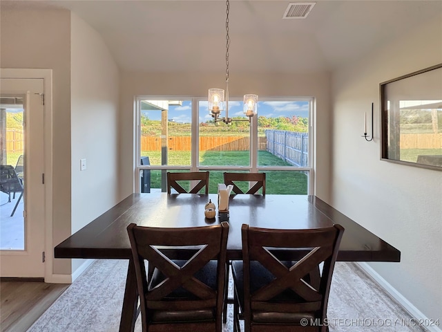 dining space with a notable chandelier, light hardwood / wood-style flooring, and a healthy amount of sunlight