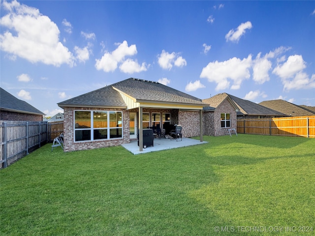 back of house with a patio and a yard