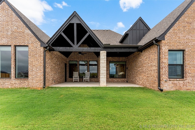 rear view of property featuring a yard and a patio area