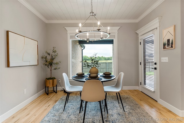 dining room with a notable chandelier, light hardwood / wood-style flooring, and crown molding