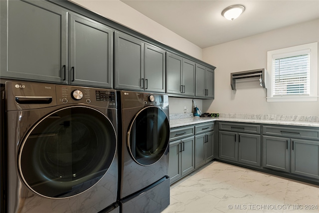 laundry room featuring cabinets and washer and dryer