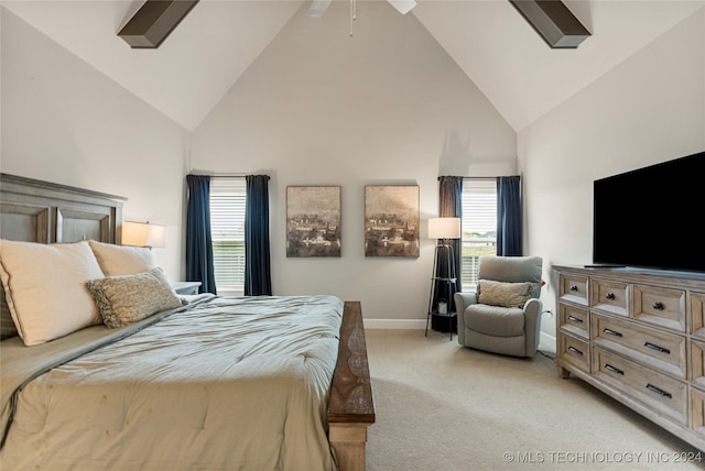 carpeted bedroom with ceiling fan and high vaulted ceiling