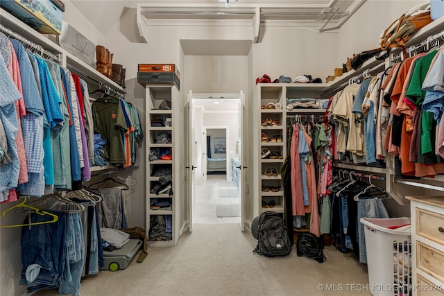 walk in closet featuring light colored carpet