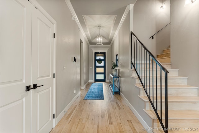 interior space featuring a notable chandelier, light hardwood / wood-style flooring, and ornamental molding