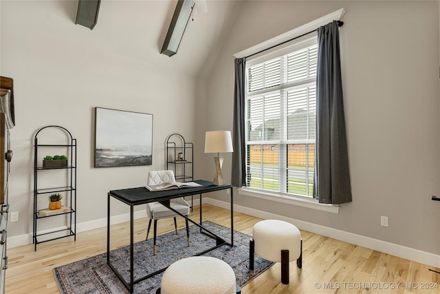 office space with vaulted ceiling, light hardwood / wood-style flooring, and a wealth of natural light