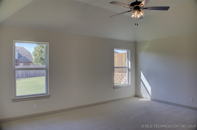 spare room with lofted ceiling, ceiling fan, light colored carpet, and plenty of natural light