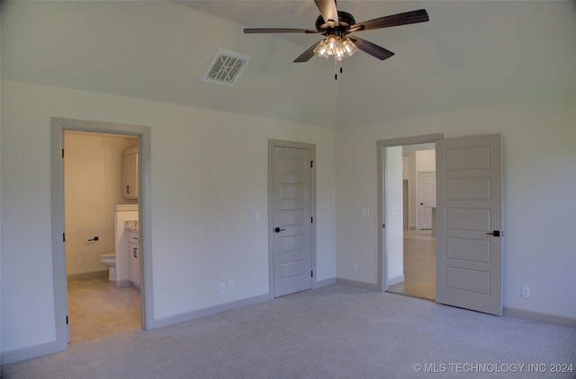 unfurnished bedroom with light colored carpet, ceiling fan, and ensuite bathroom