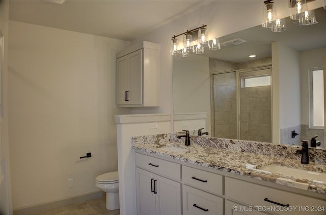 bathroom with tiled shower, vanity, and toilet