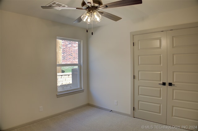 carpeted empty room featuring ceiling fan