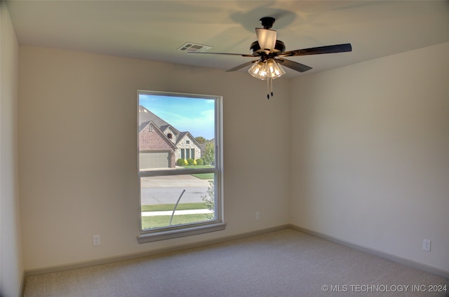 carpeted spare room with ceiling fan