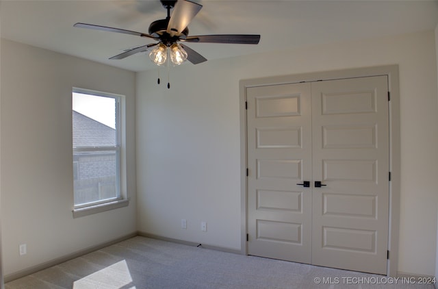 unfurnished bedroom with light carpet, a closet, and ceiling fan