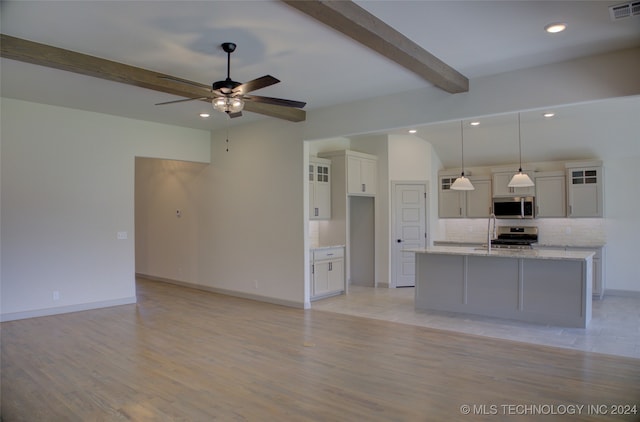 unfurnished living room with beamed ceiling, ceiling fan, and light hardwood / wood-style flooring