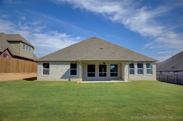 rear view of property featuring a yard and a patio area