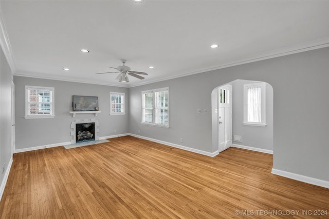 unfurnished living room featuring a healthy amount of sunlight, light hardwood / wood-style floors, crown molding, and ceiling fan