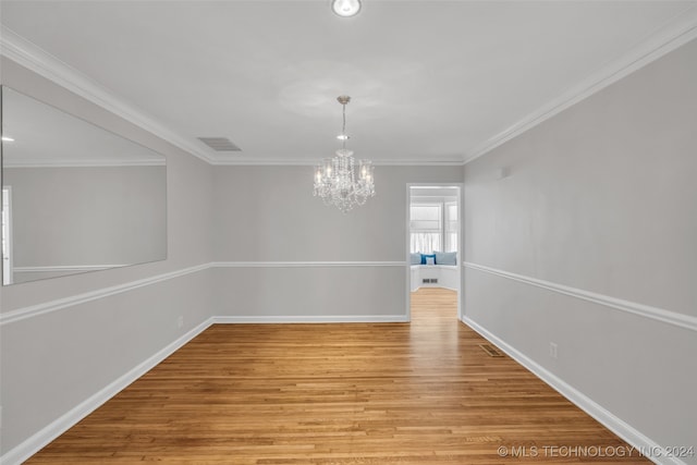 unfurnished room with crown molding, an inviting chandelier, and light hardwood / wood-style flooring