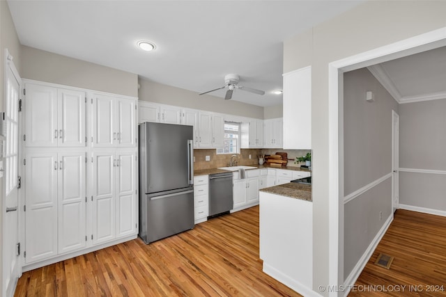 kitchen featuring ceiling fan, white cabinets, ornamental molding, stainless steel appliances, and light hardwood / wood-style floors