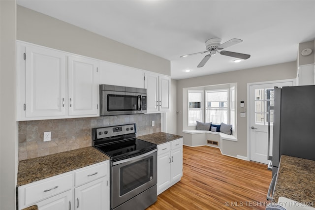 kitchen with ceiling fan, white cabinetry, appliances with stainless steel finishes, light hardwood / wood-style floors, and decorative backsplash