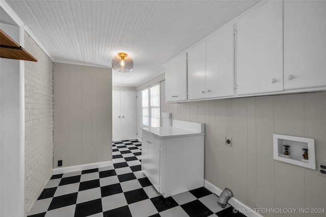 clothes washing area featuring hookup for a washing machine, brick wall, hookup for an electric dryer, cabinets, and wooden walls