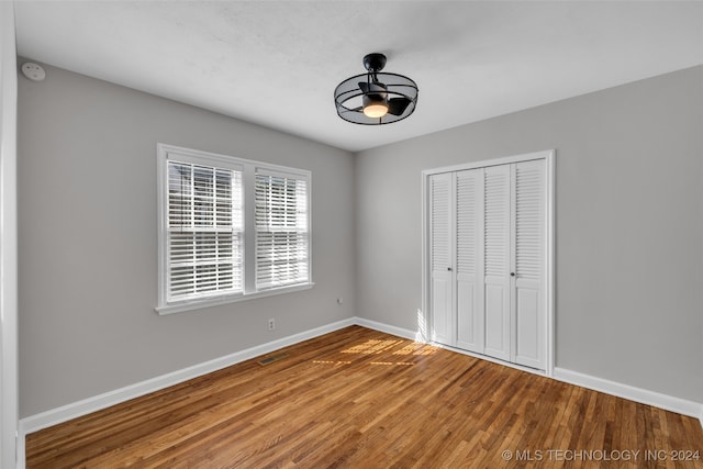 unfurnished bedroom with wood-type flooring and a closet