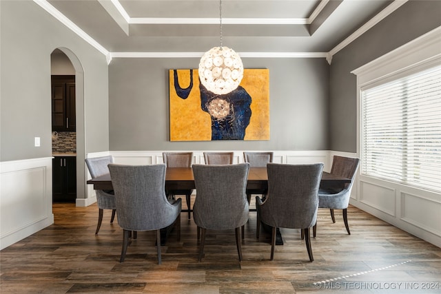 dining space featuring dark hardwood / wood-style flooring, a tray ceiling, crown molding, and a notable chandelier