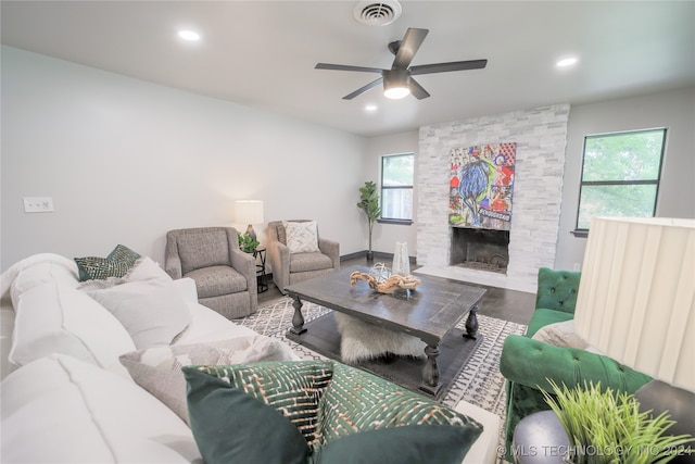 living room with hardwood / wood-style floors, a stone fireplace, plenty of natural light, and ceiling fan