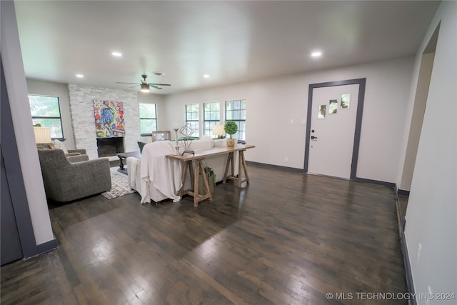 living room featuring dark hardwood / wood-style floors, ceiling fan, and a healthy amount of sunlight