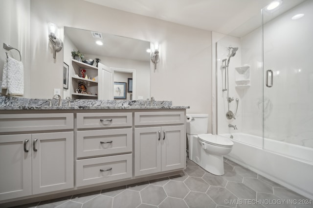 full bathroom featuring vanity, toilet, tile patterned floors, and bath / shower combo with glass door