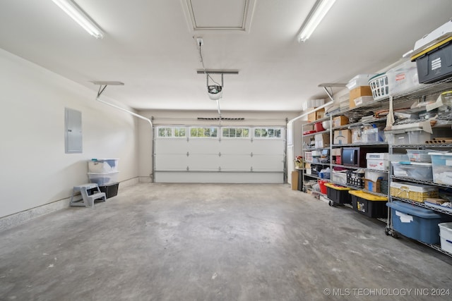 garage with a garage door opener and electric panel