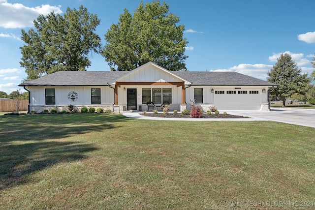 view of front of property featuring a garage, a porch, and a front lawn