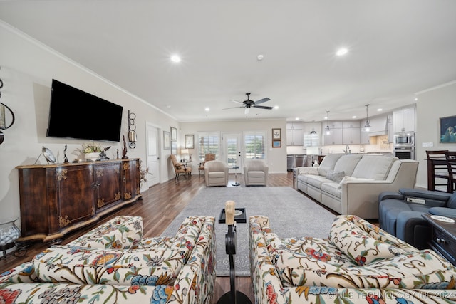 living room with ornamental molding, ceiling fan, and dark hardwood / wood-style floors