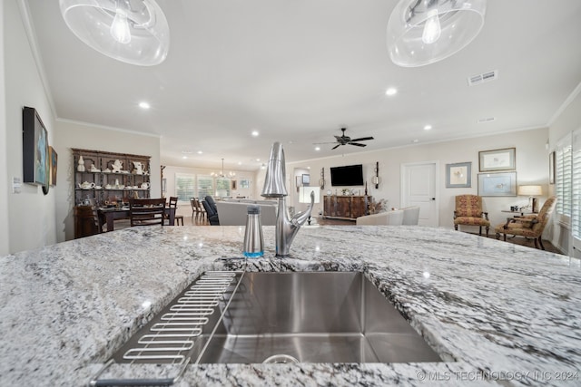 kitchen featuring ornamental molding, light stone counters, and ceiling fan