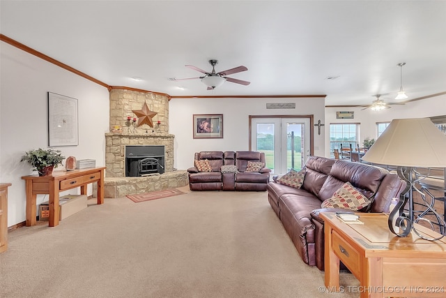 carpeted living room featuring a fireplace, ornamental molding, ceiling fan, and french doors