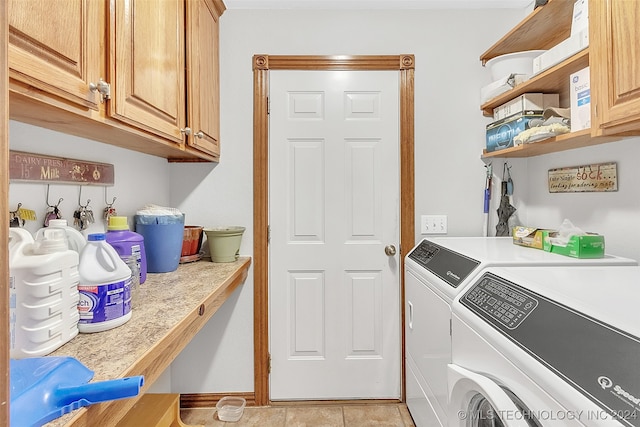 laundry room with washing machine and dryer, light tile patterned flooring, and cabinets