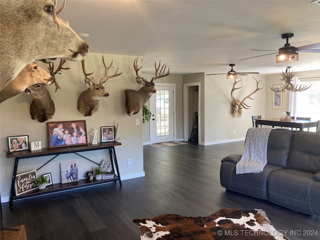 living room featuring ceiling fan, plenty of natural light, and dark hardwood / wood-style flooring