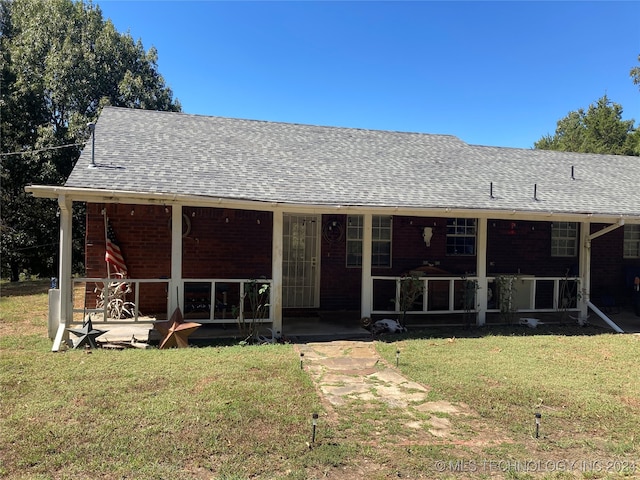 rear view of house featuring a yard