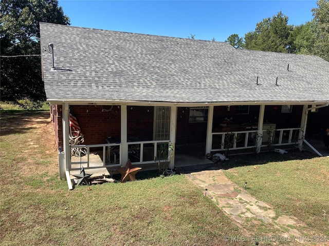 back of house featuring a lawn and a sunroom