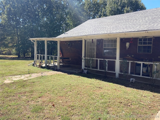 view of home's exterior featuring a sunroom and a yard