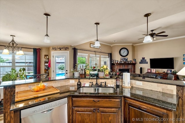 kitchen with a brick fireplace, ceiling fan with notable chandelier, plenty of natural light, and stainless steel dishwasher