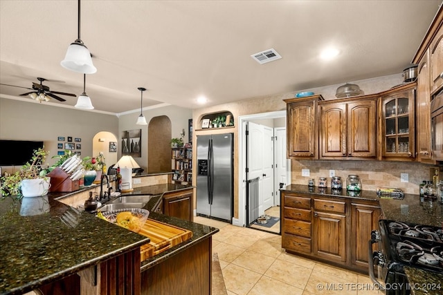 kitchen featuring black gas stove, hanging light fixtures, ceiling fan, and stainless steel fridge with ice dispenser