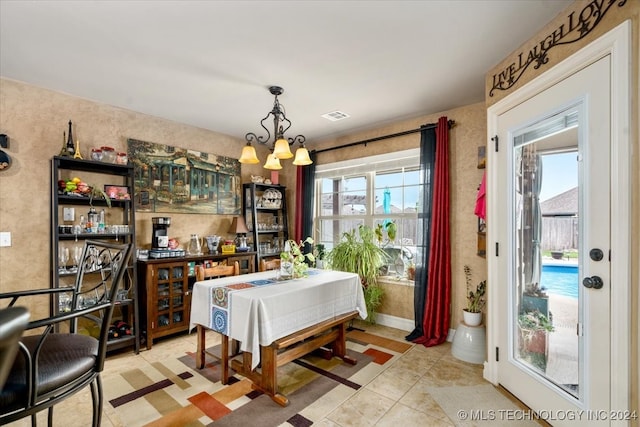 tiled dining room with plenty of natural light and a chandelier