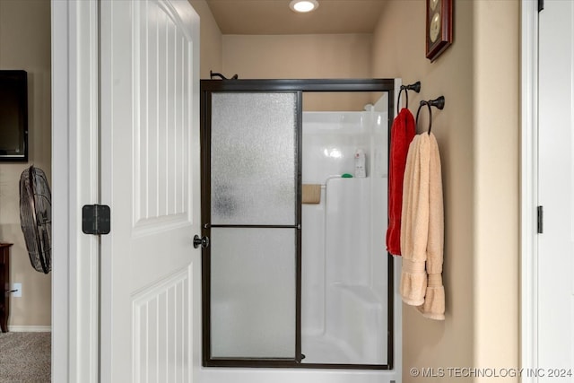 bathroom featuring a shower with door