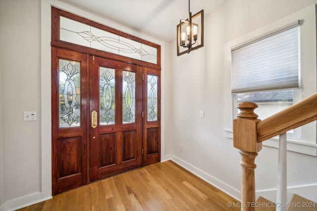 entryway with french doors, an inviting chandelier, light hardwood / wood-style flooring, and plenty of natural light